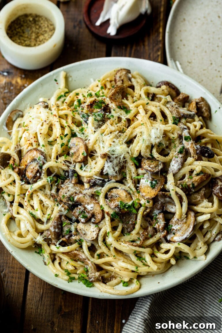 Weekly Meal Plan: October 2–8 (7-Day Menu Guide) 4 a photo of a large white serving plate full of creamy pasta and mushrooms topped with shaved parmesan and chopped parsley.