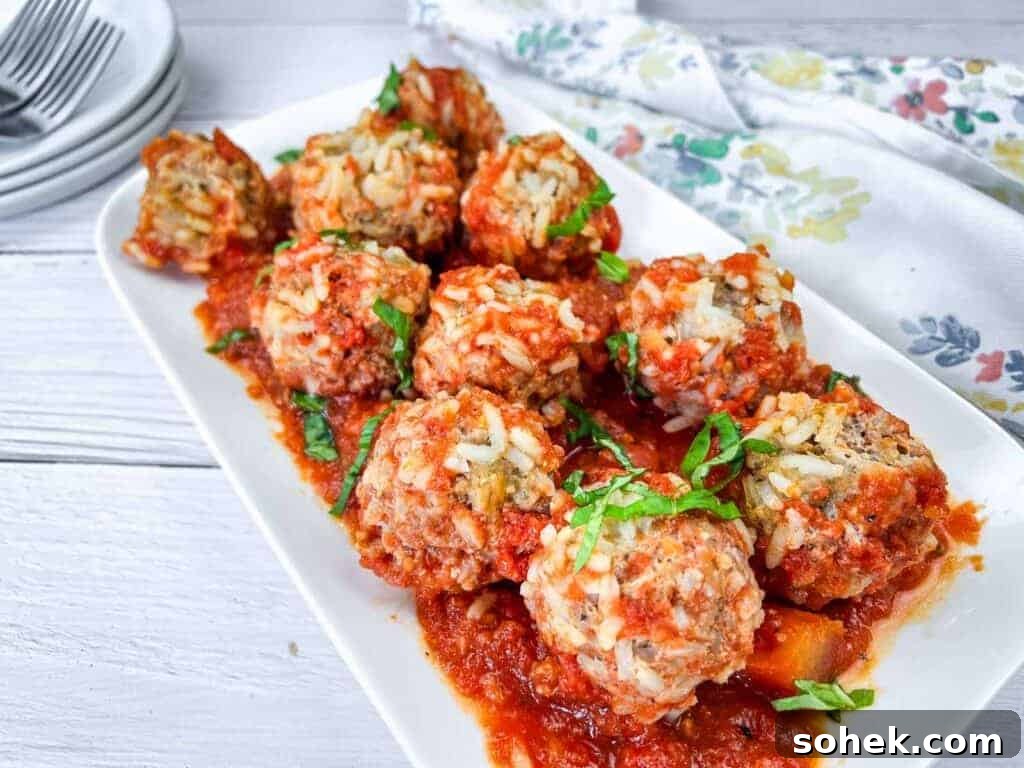21 Quick Ground Beef Dinners That Will Have Everyone Asking Your Secret 5 A white rectangular plate with slow cooker porcupine meatballs, garnished with fresh herbs.