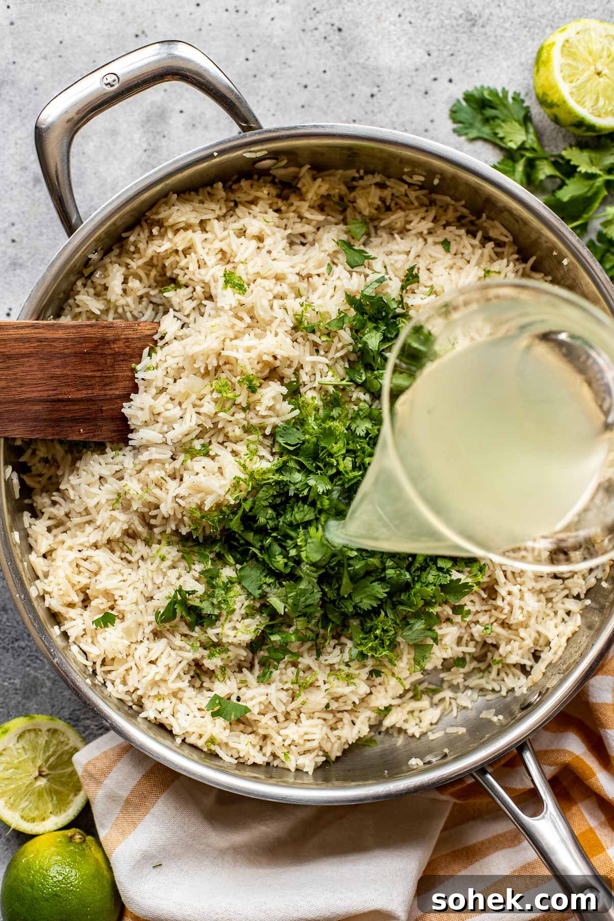 Broth being poured onto rice in a saute pan. 