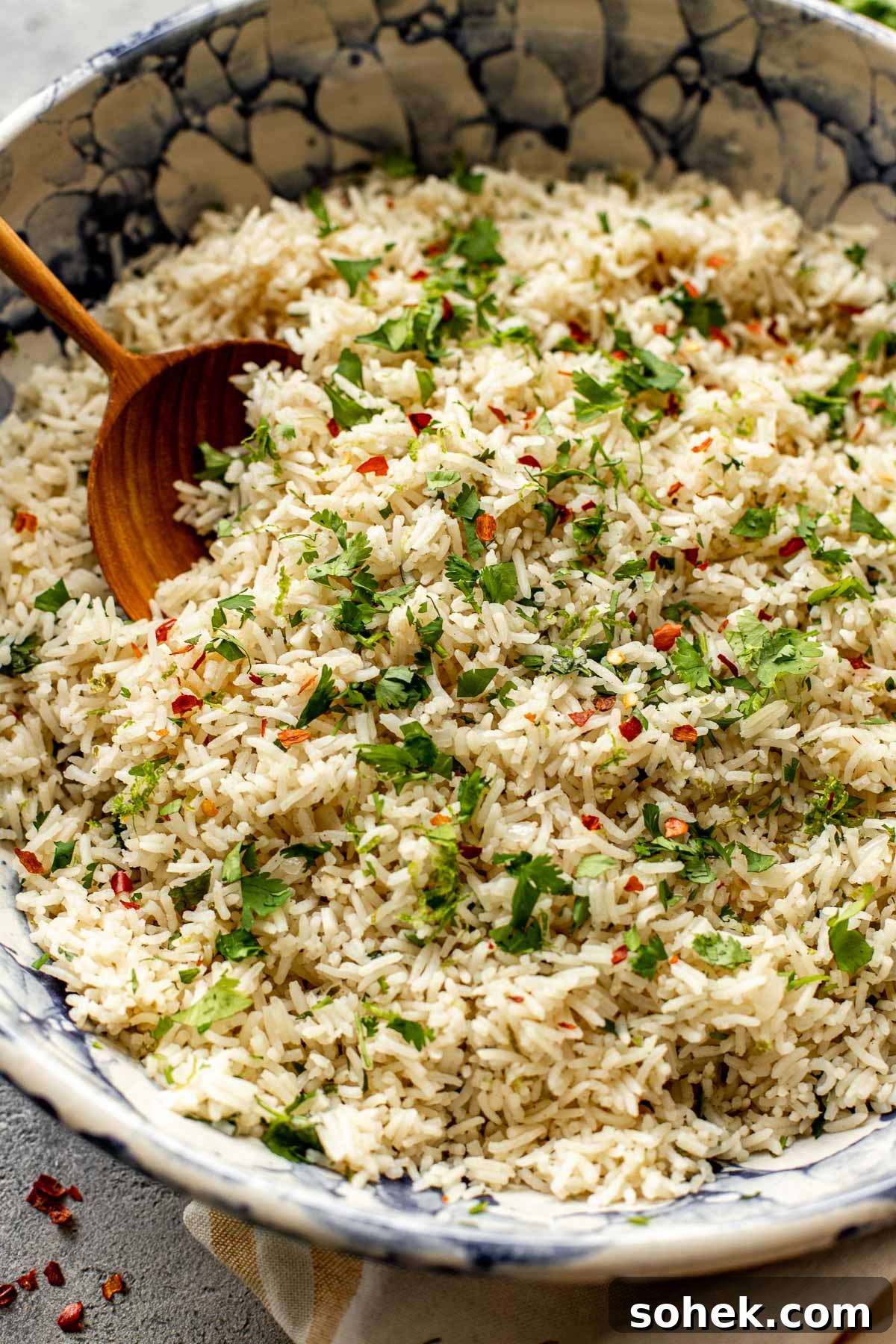 Cilantro lime rice in a blue and white bowl with cilantro on top. 