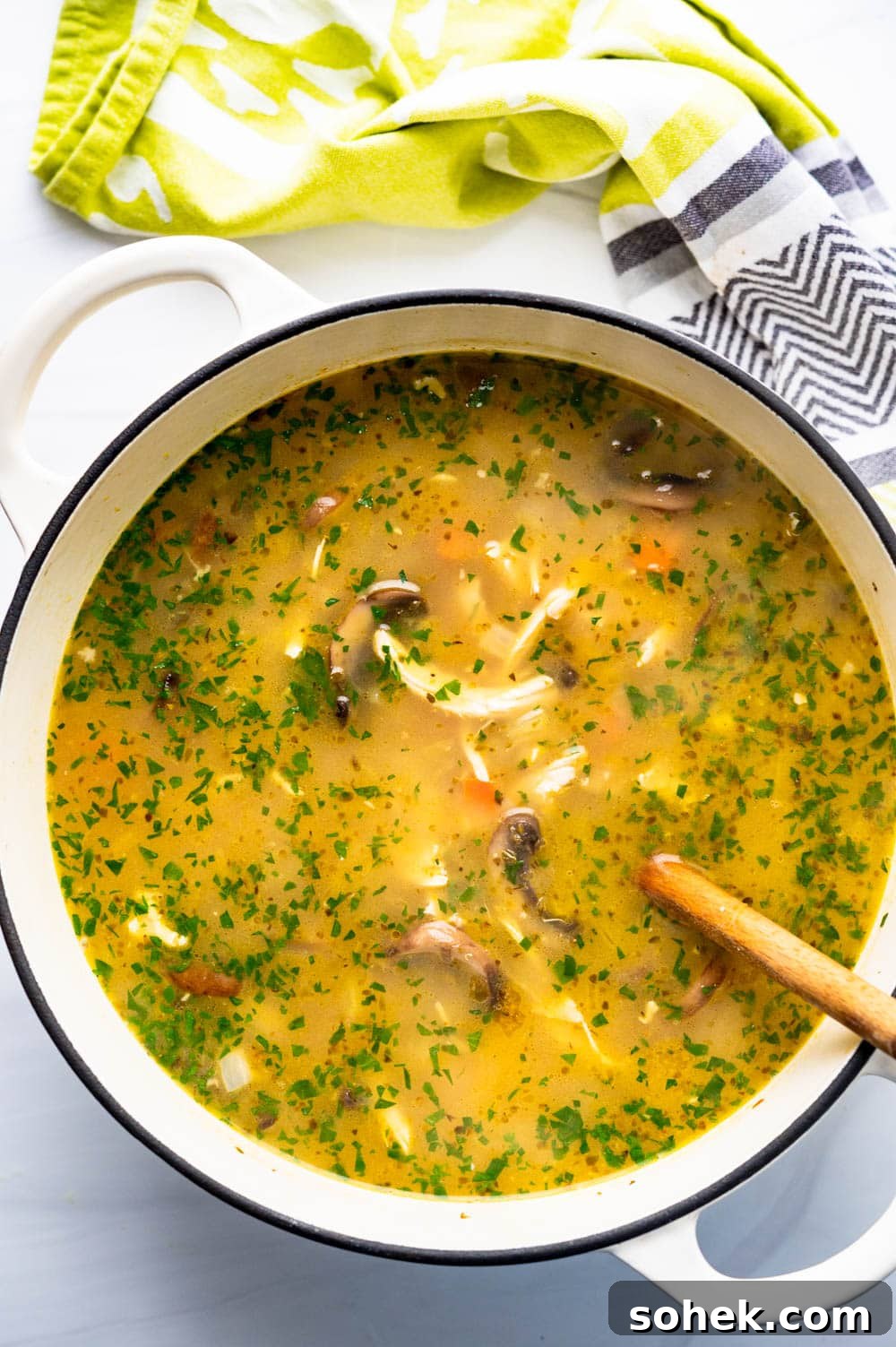 adding parsley to the soup to finish it.