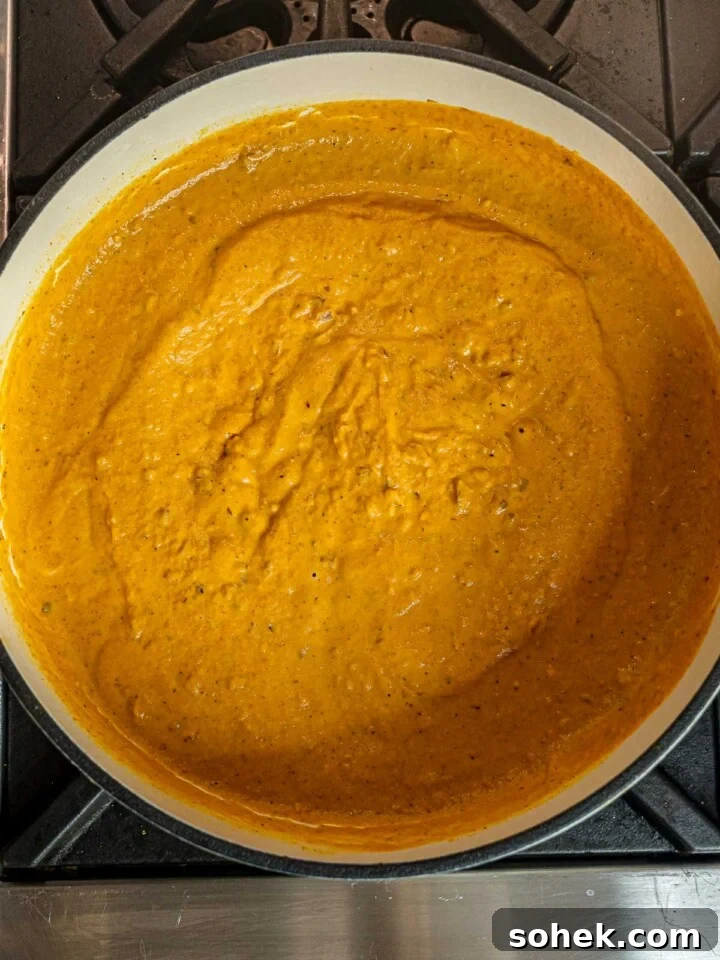 Creamy Pumpkin Pasta Sauce Recipe: Vegan, Savory Fall Dinner 7 Thick pumpkin pasta sauce simmering until smooth and velvety in a Dutch oven.