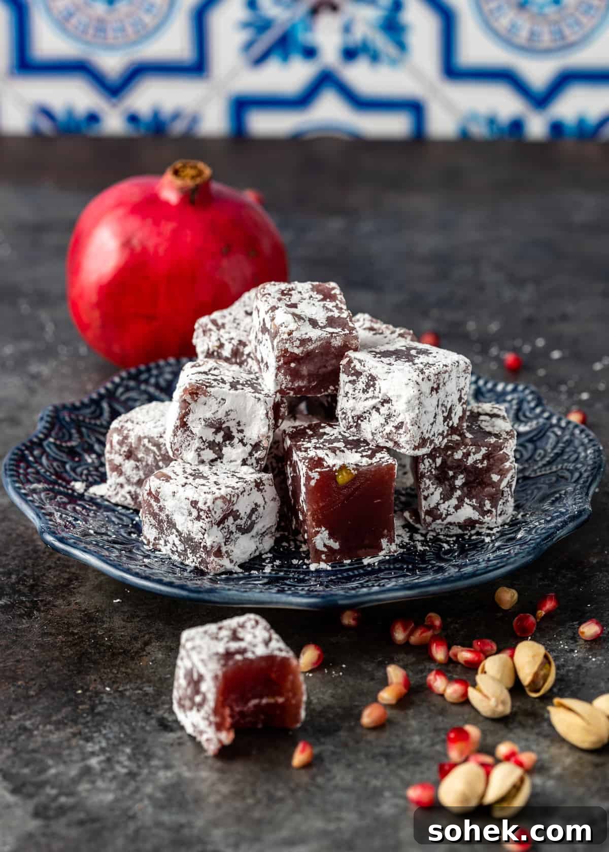 Authentic Turkish Delight (Lokum) Recipe for Soft, Chewy Sweets 20 side view of pomegranate and pistachio gelatin candy on plate