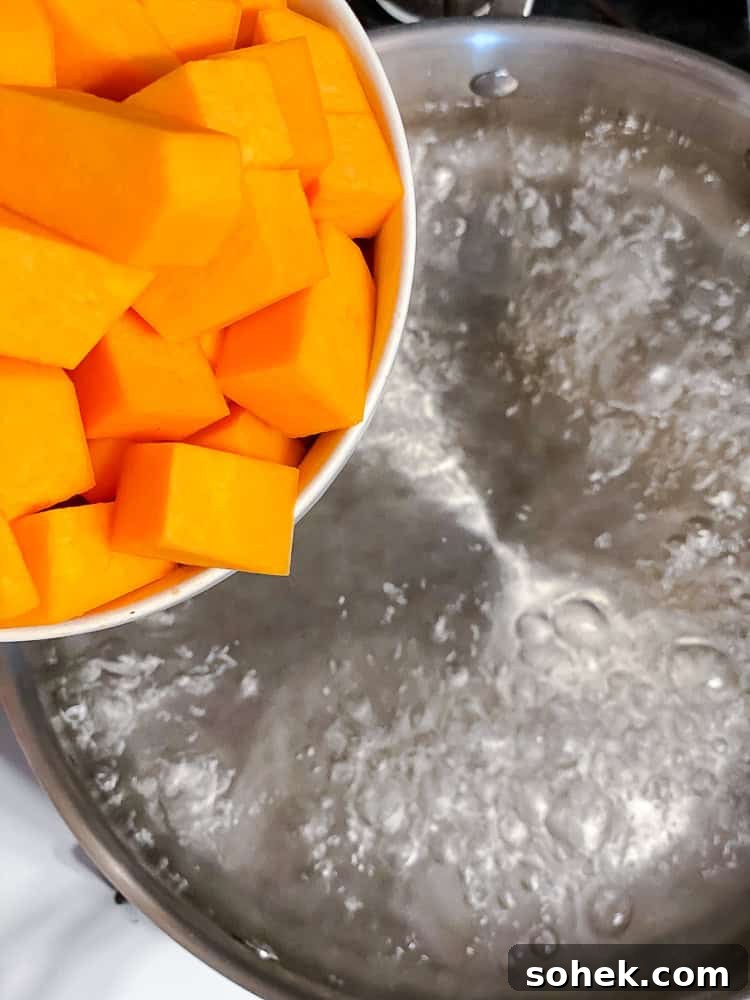 Creamy Butternut Squash Macaroni and Cheese Recipe 4 process shot showing adding butternut squash to pot
