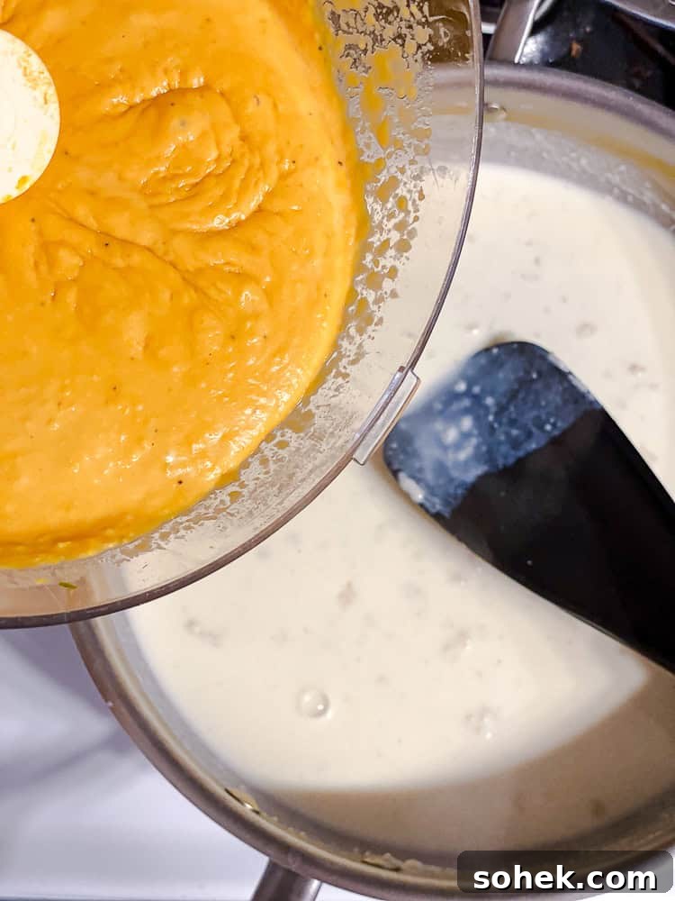 Creamy Butternut Squash Macaroni and Cheese Recipe 7 process shot showing adding butternut squash mixture to pan