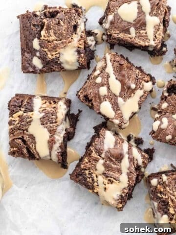 tahini brownies on a white background drizzled with tahini sauce