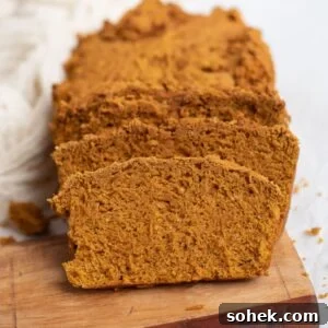Sliced pumpkin bread on a wooden serving board