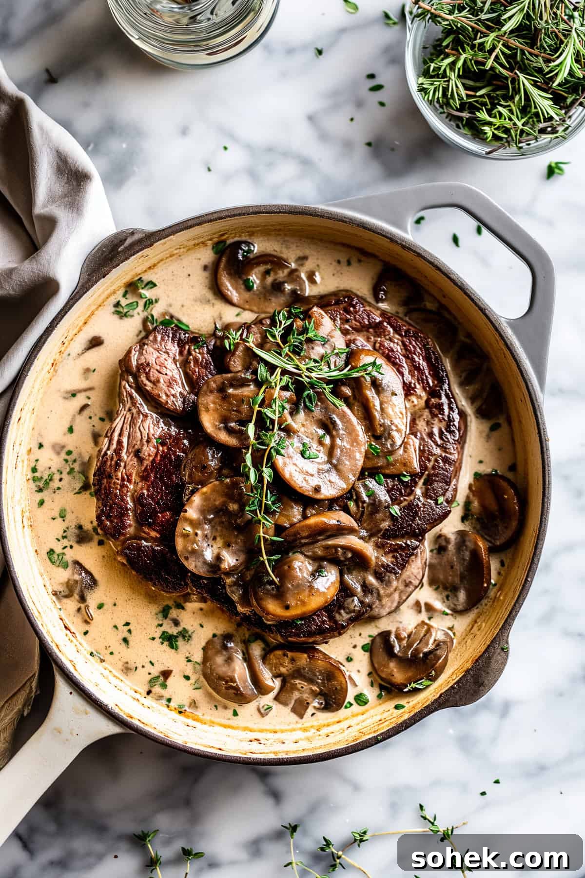 Pan-seared steak with cream mushroom sauce and herbs.