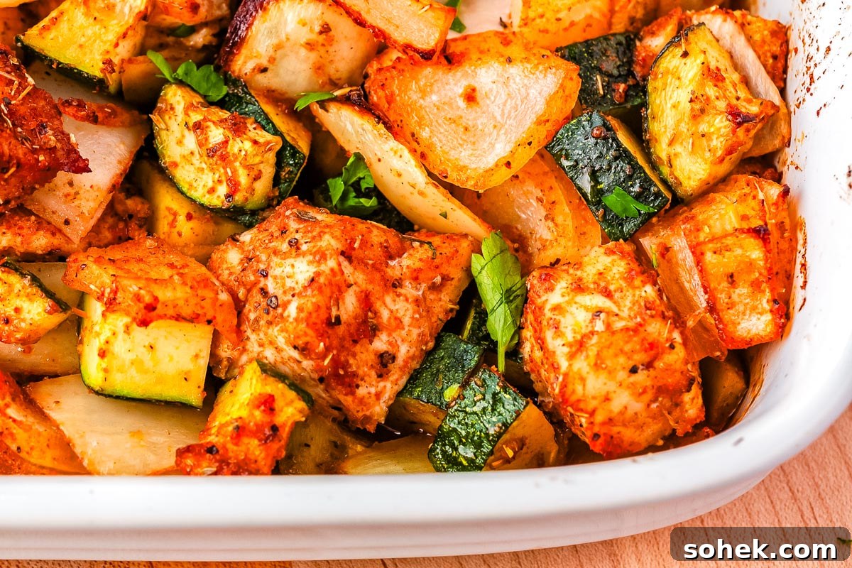 A close up of the finished zucchini and chicken bake in a caserole dish.