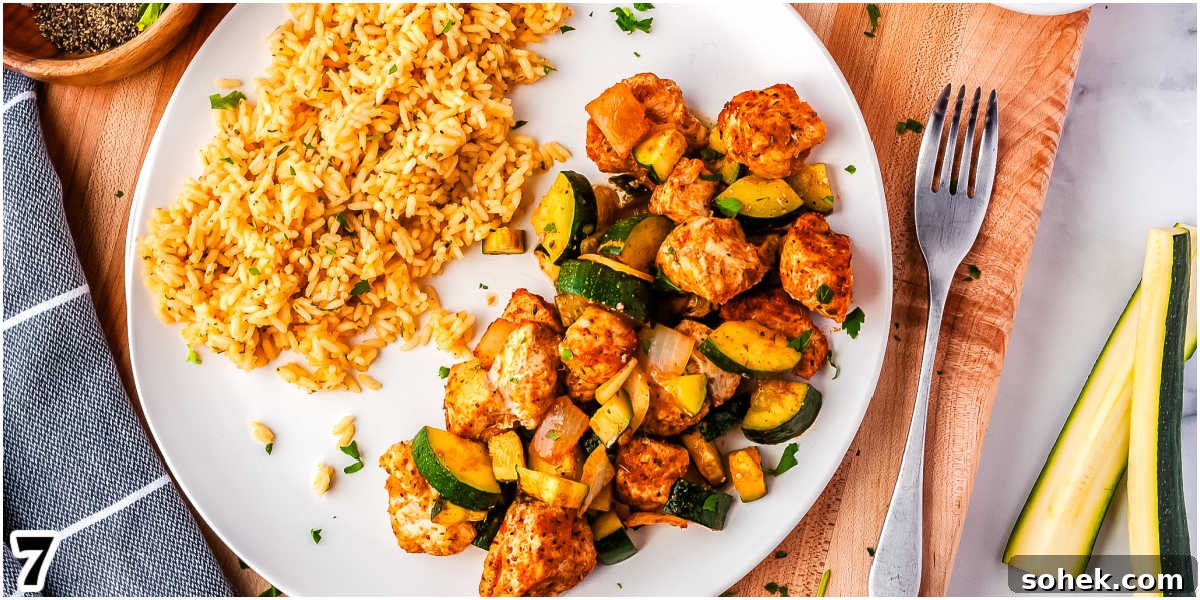 some chicken zucchini bake and rice on a white plate.