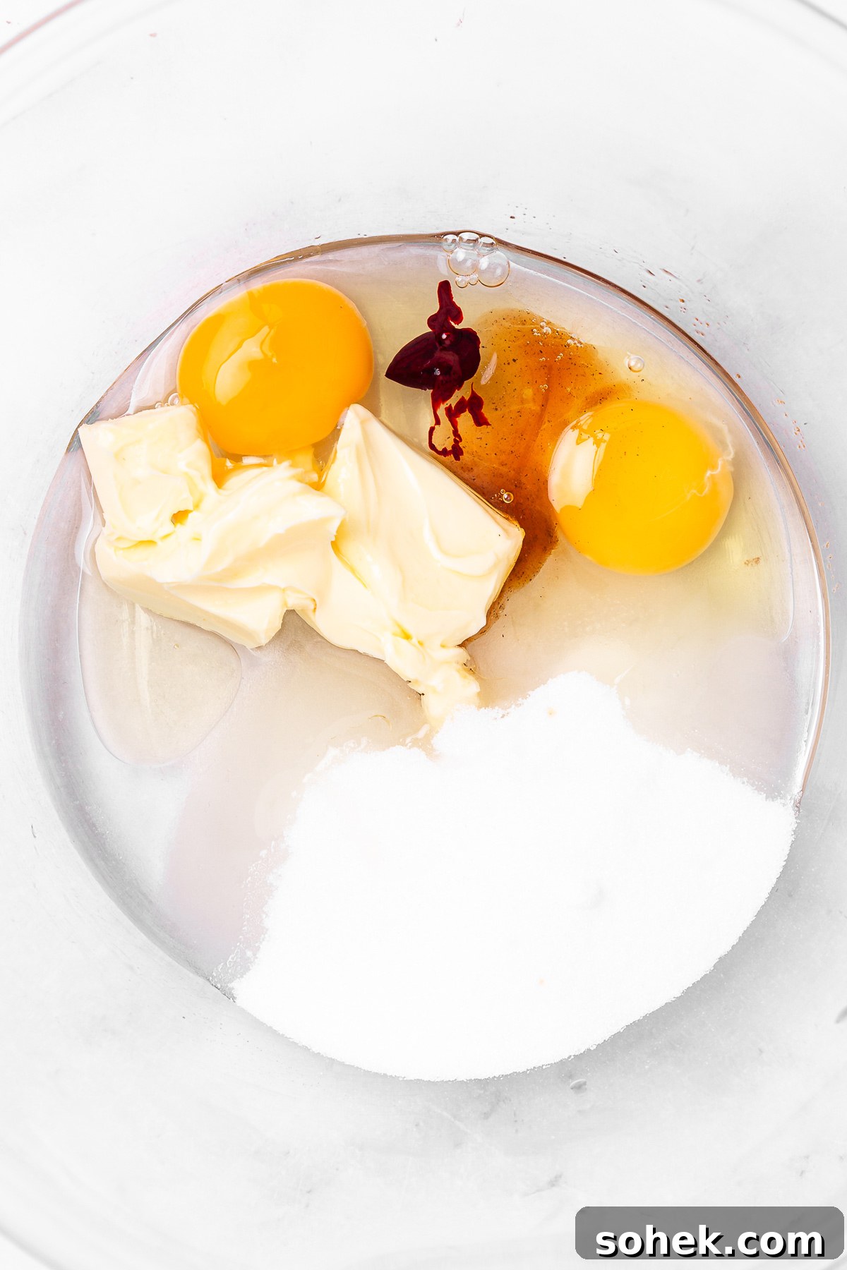 mixing butter oil egg sugar vanilla for red velvet cupcakes