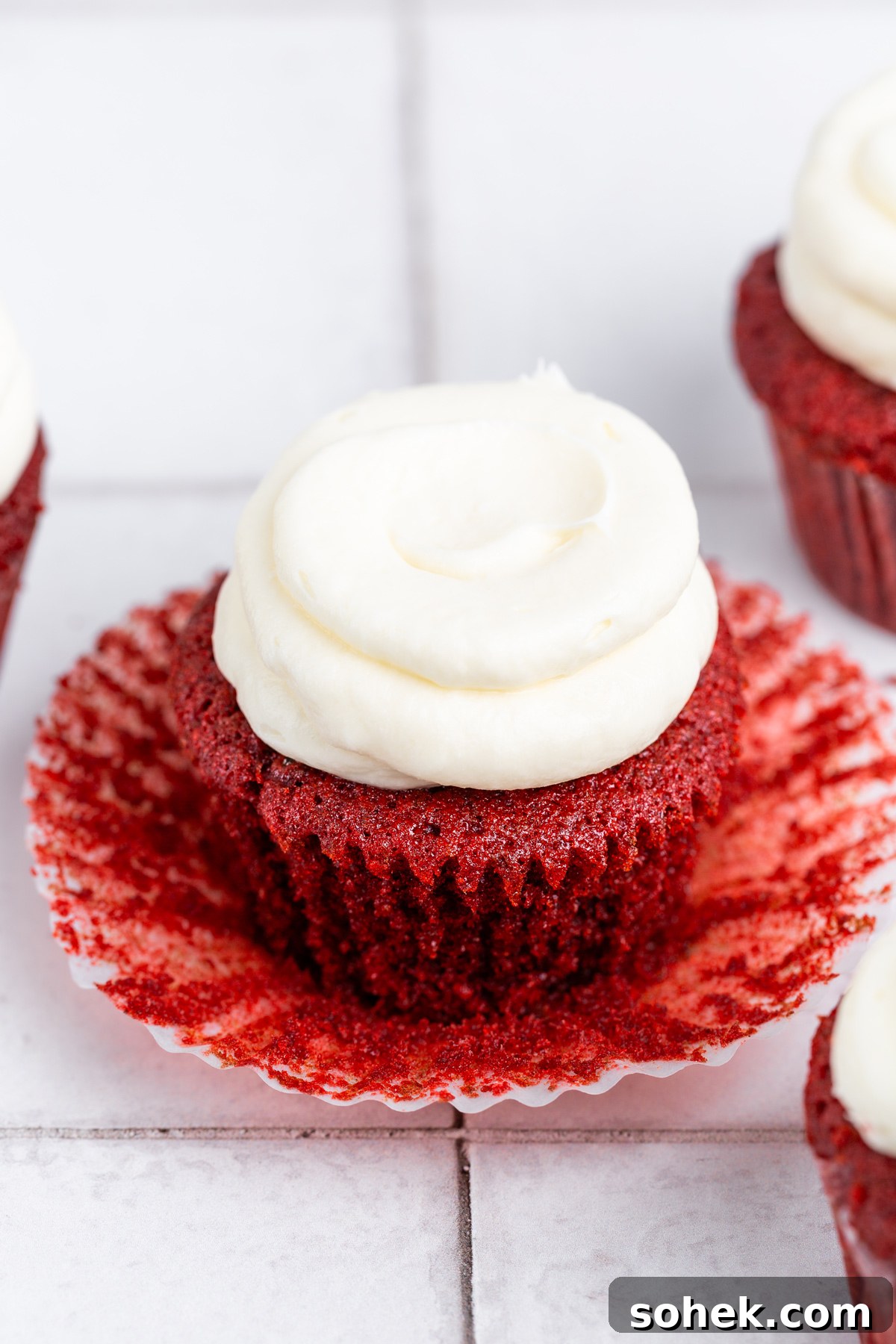 red velvet cupcakes with cream cheese frosting on a table