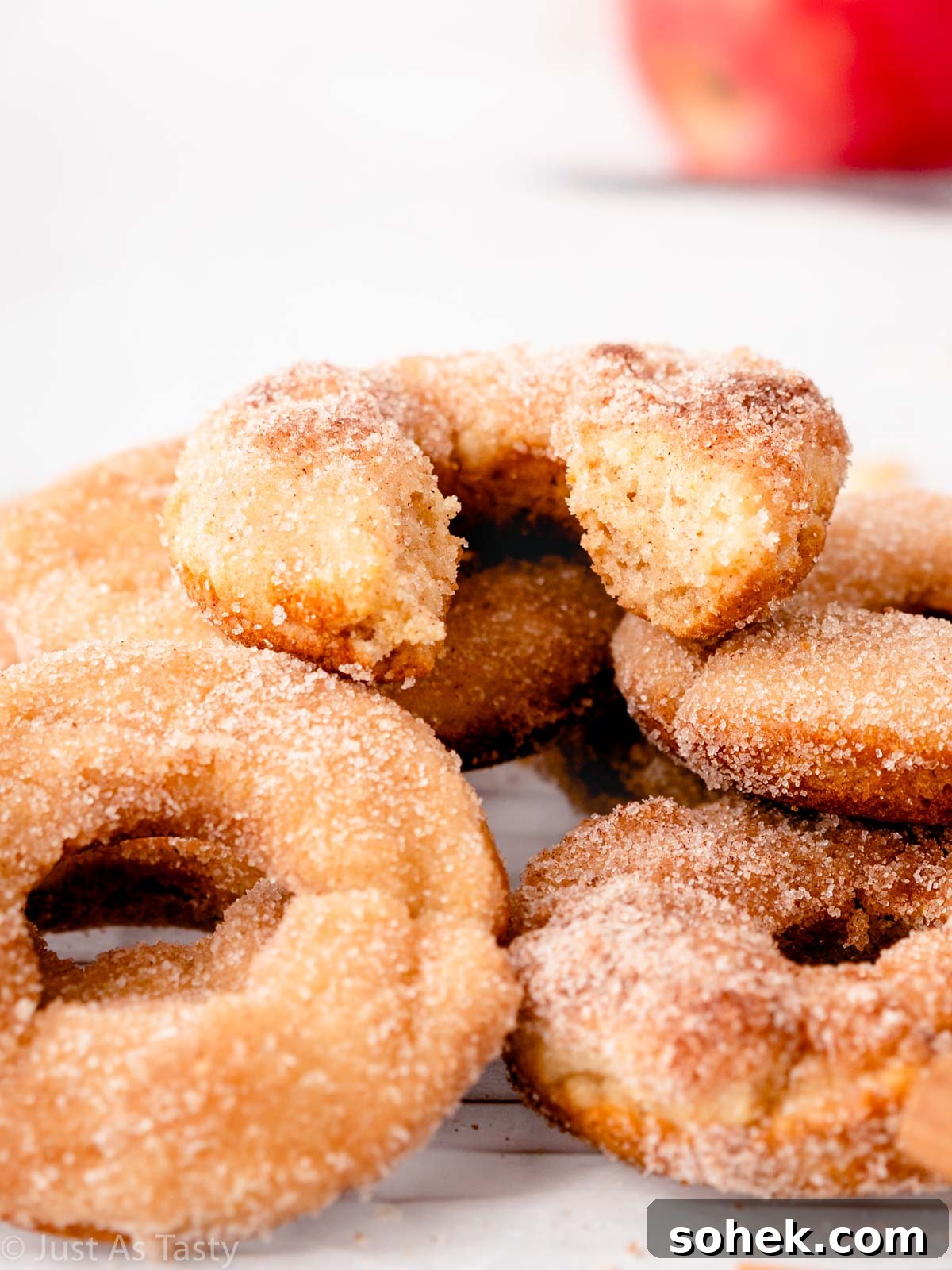 Gluten free apple cider donut with a bite taken out of it.