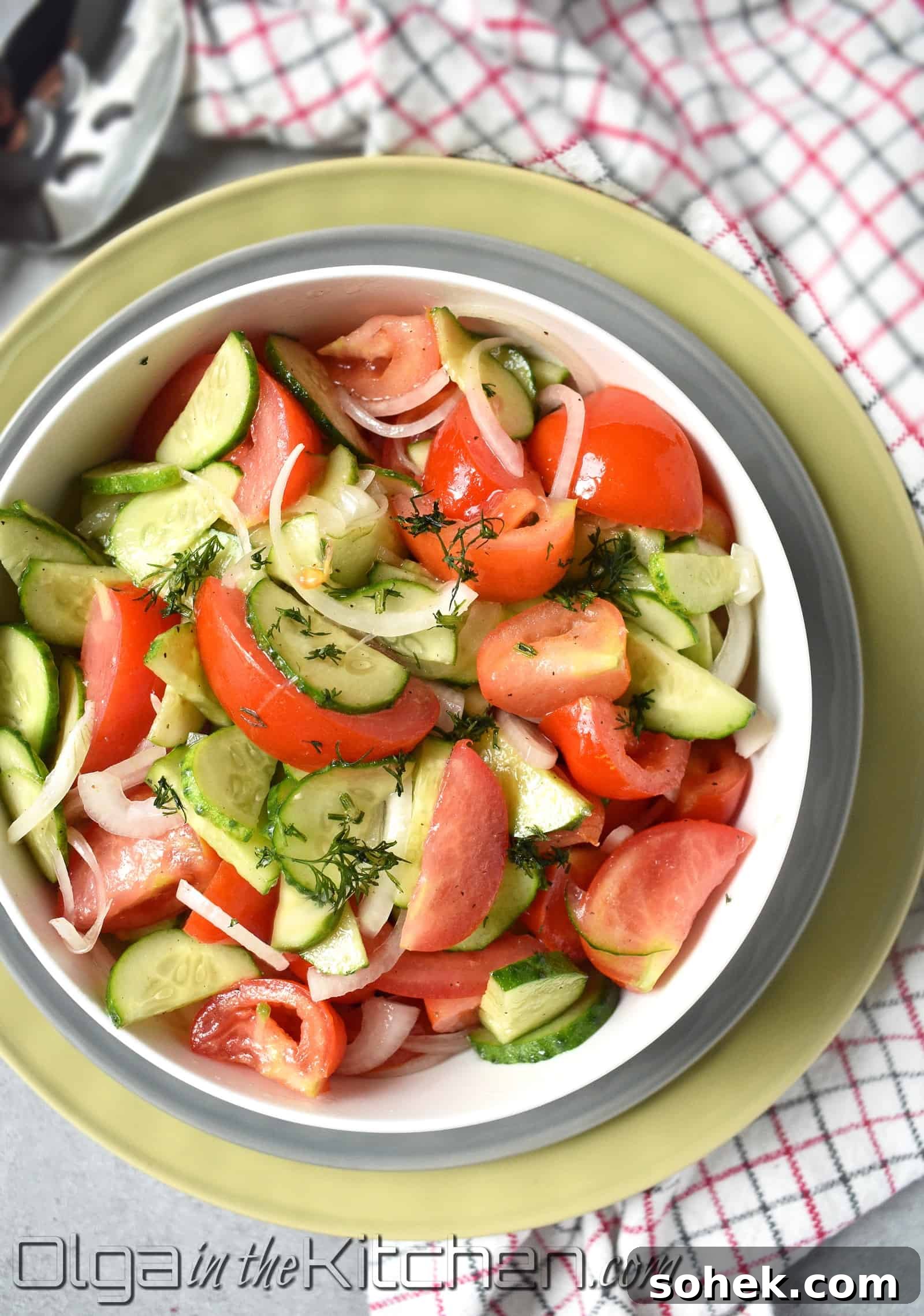Tomato and cucumber salad with onion in a bowl.