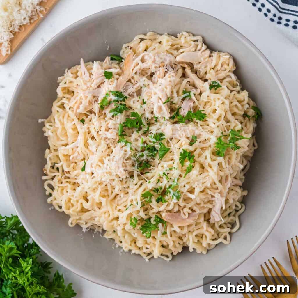Bowl of garlic parmesan chicken ramen with parsley garnish