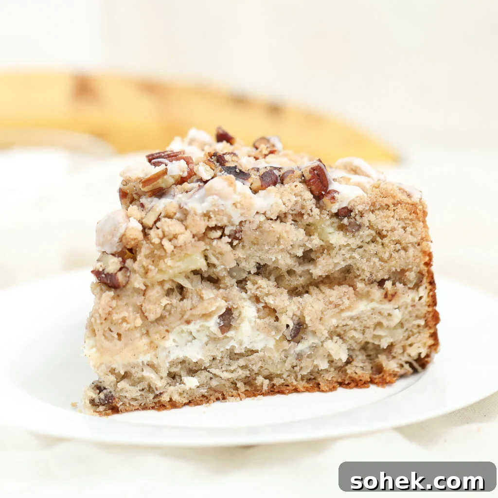 Hummingbird coffee cake topped with cream cheese glaze on a white plate.