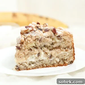 Slice of hummingbird coffee cake with cream cheese and glaze on white plate.