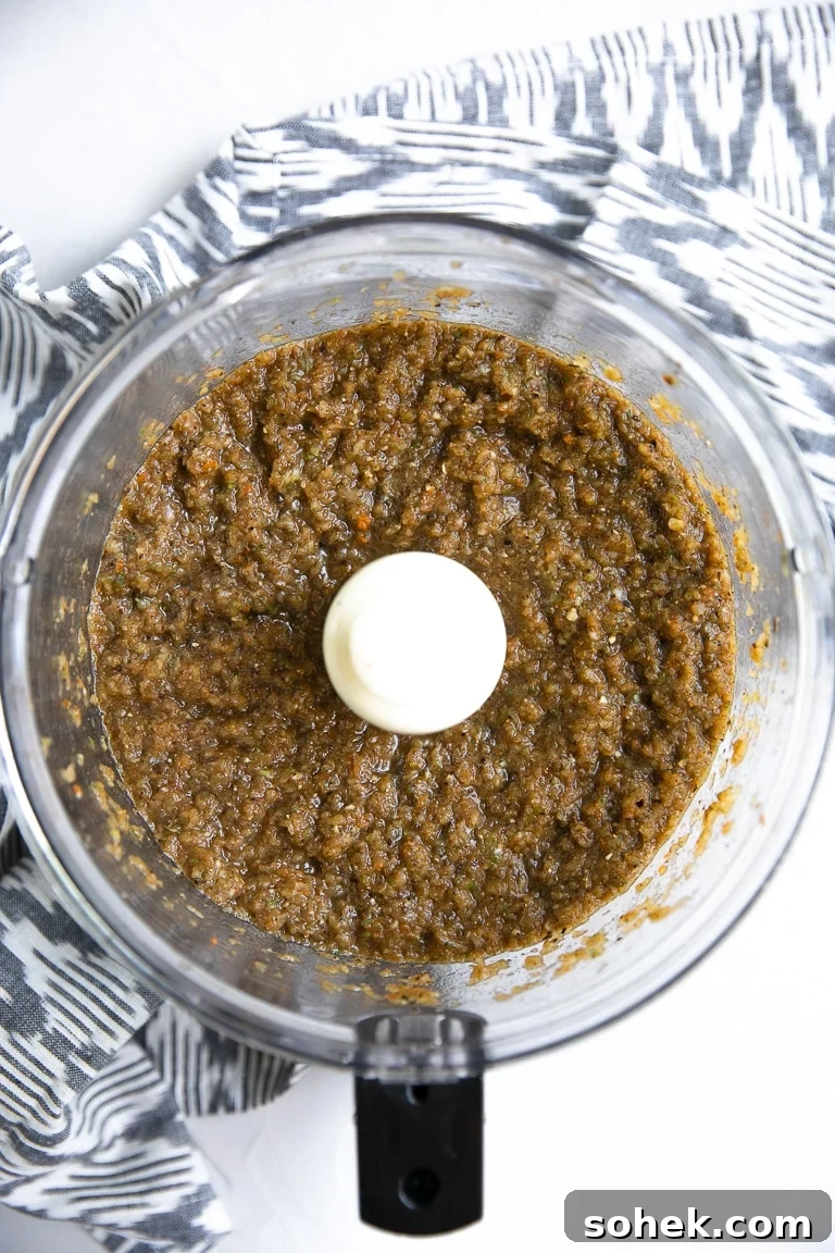 Food processor filled with blended jerk marinade.