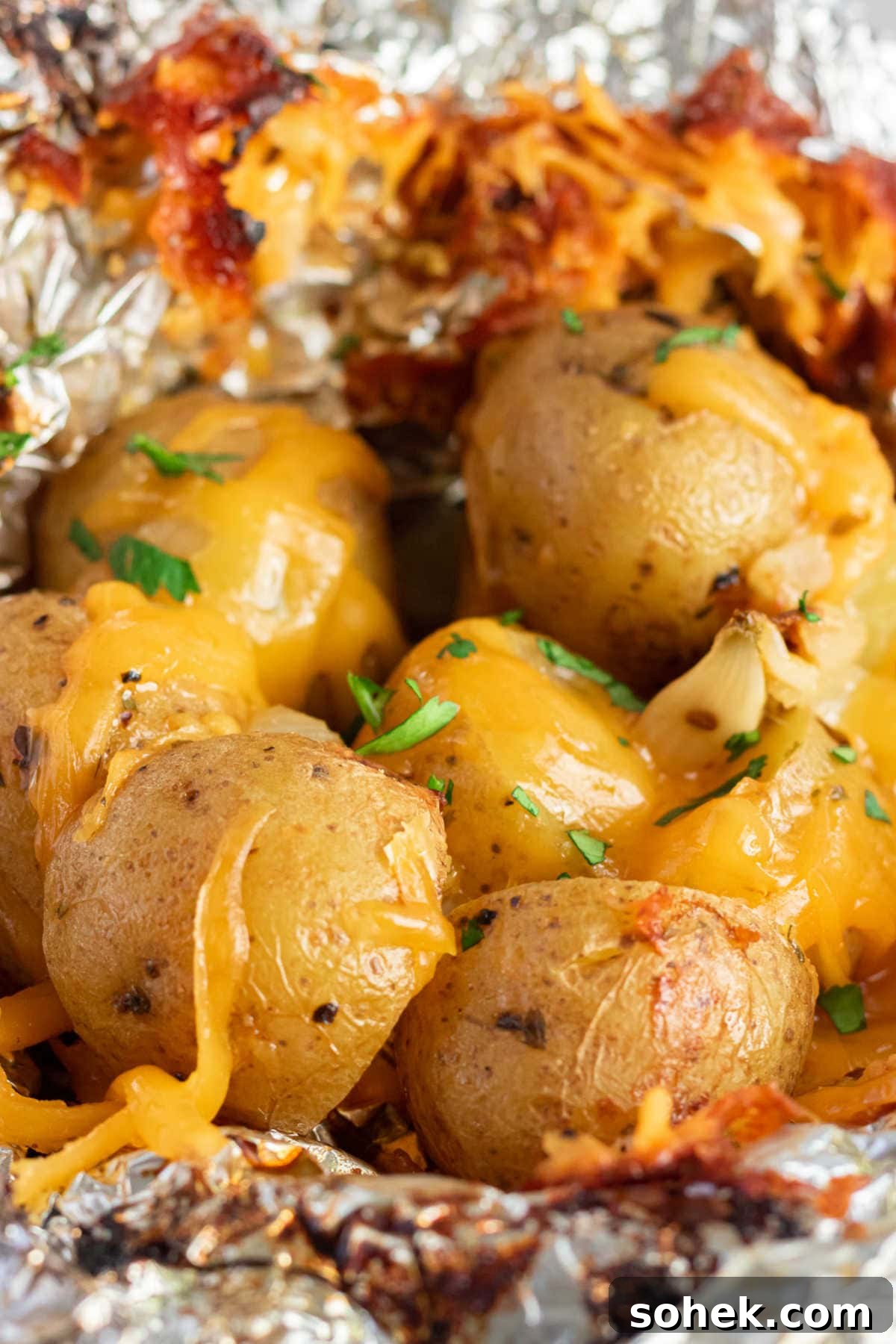 Open foil packet with cooked Yukon Gold potatoes inside.