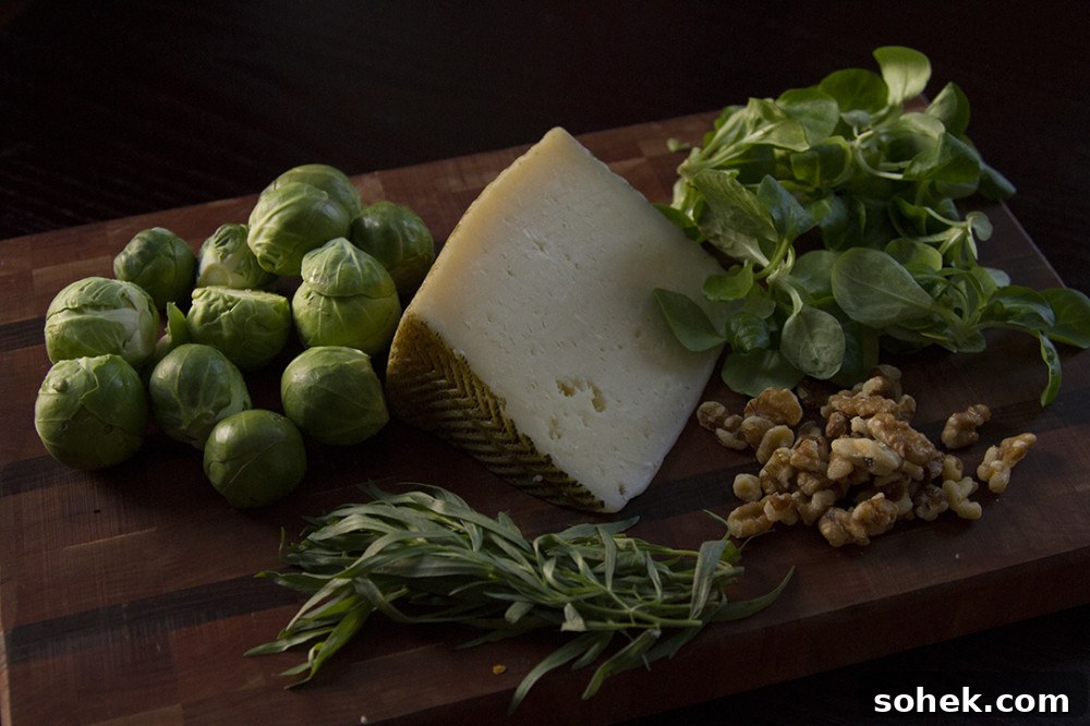 Brussels sprouts, Iberico cheese, mache, tarragon, and walnuts on a wooden cutting board.