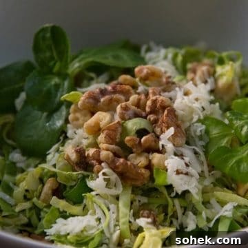 Shaved brussels sprouts salad in a white bowl.