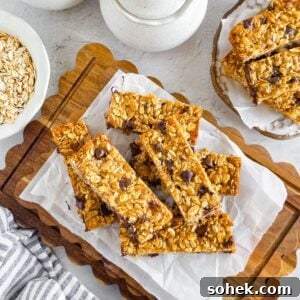 Chewy Einkorn Granola Bars with oats and chocolate chips on a wooden board.